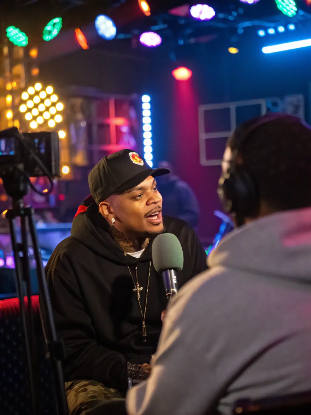 A behind-the-scenes shot of a music video shoot supported by EXPLORAPPEUR, featuring the artist, production crew, and EXPLORAPPEUR staff collaborating on set. The atmosphere is creative and collaborative.